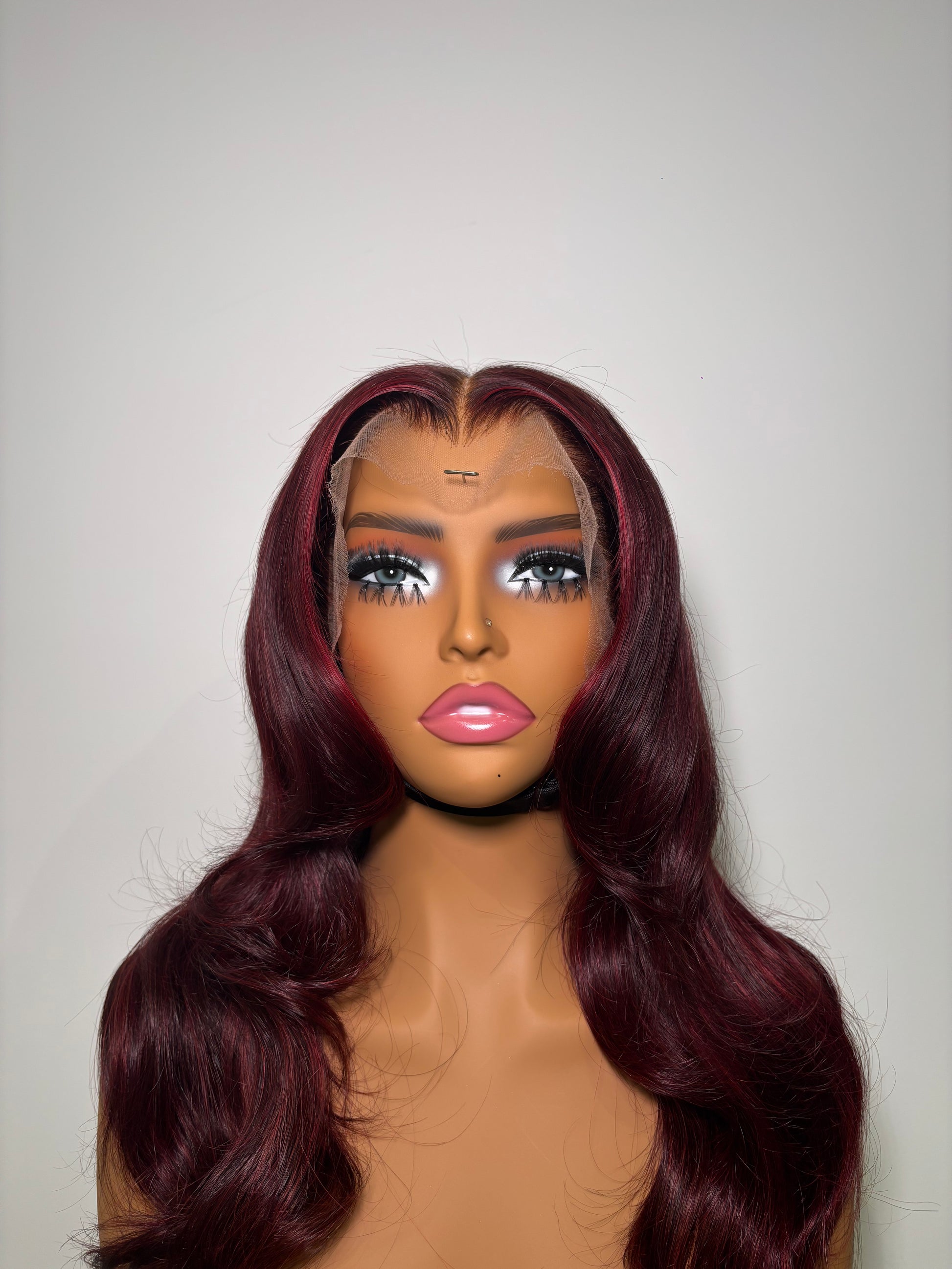 Mannequin head with burgundy wig on a white background