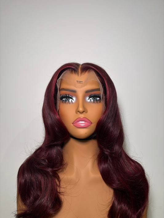 Mannequin head with burgundy wig on a white background