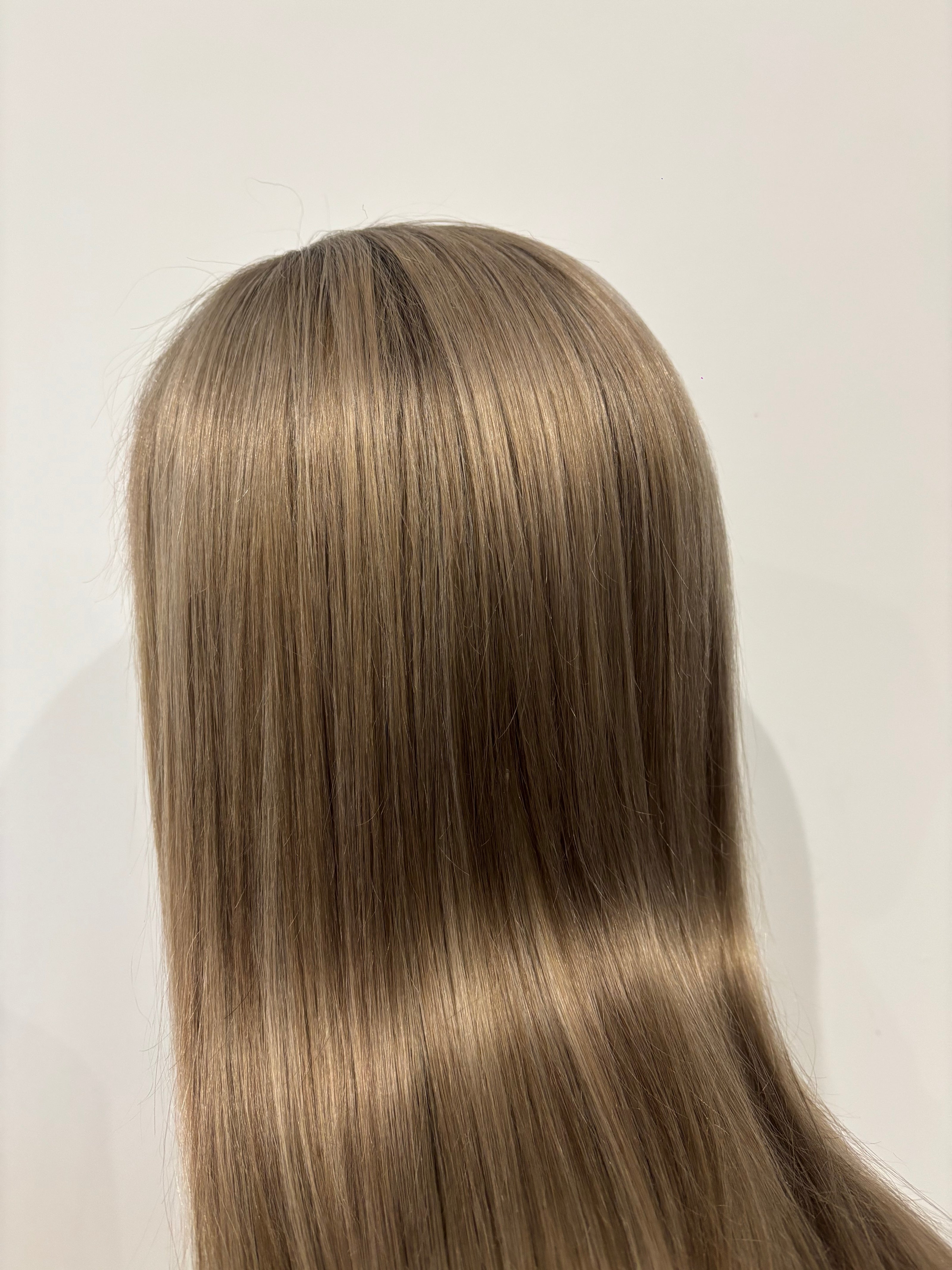 Close-up of a beige blonde wig on a white background