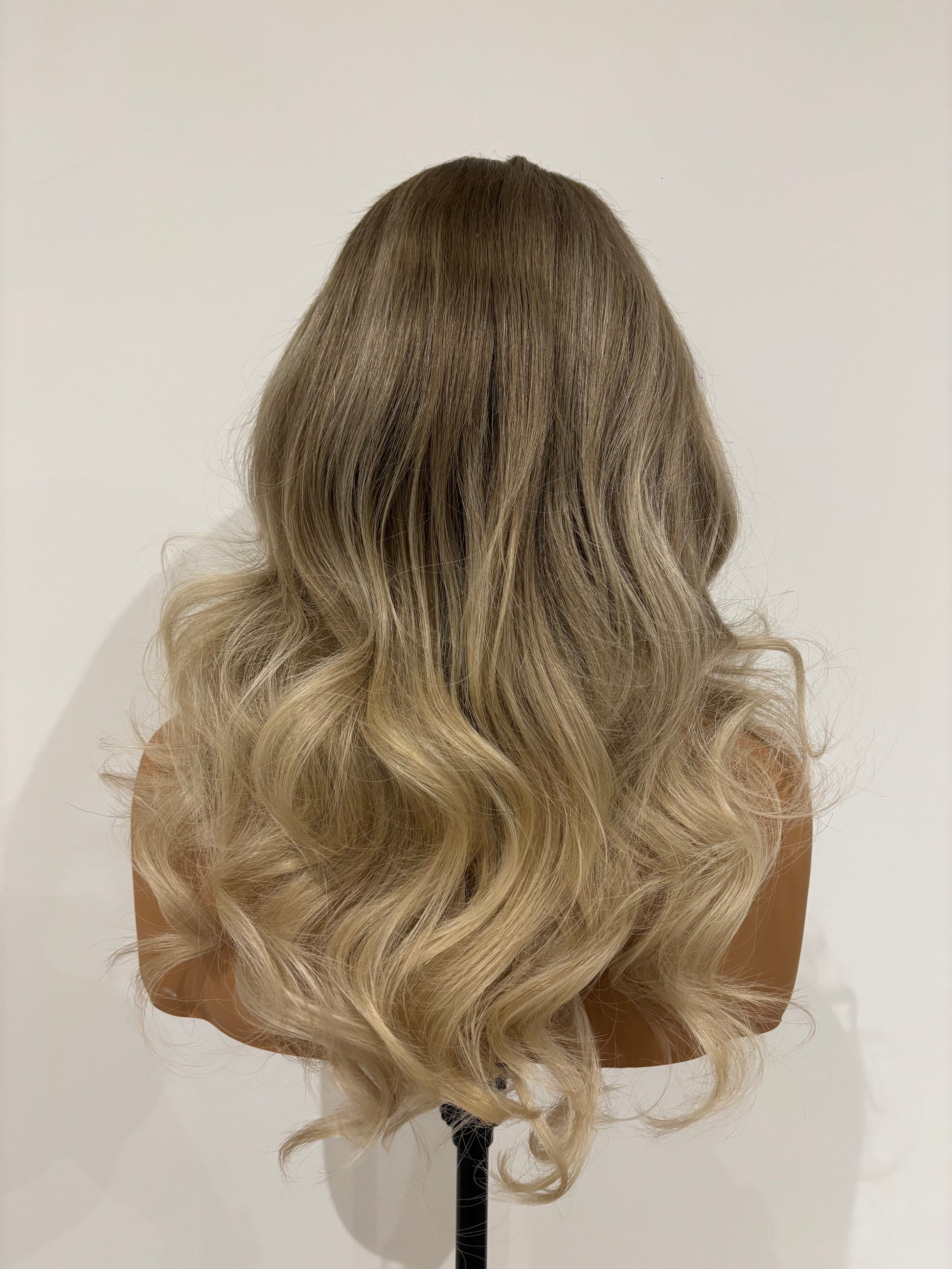 Curled blonde hair on a mannequin head against a white background