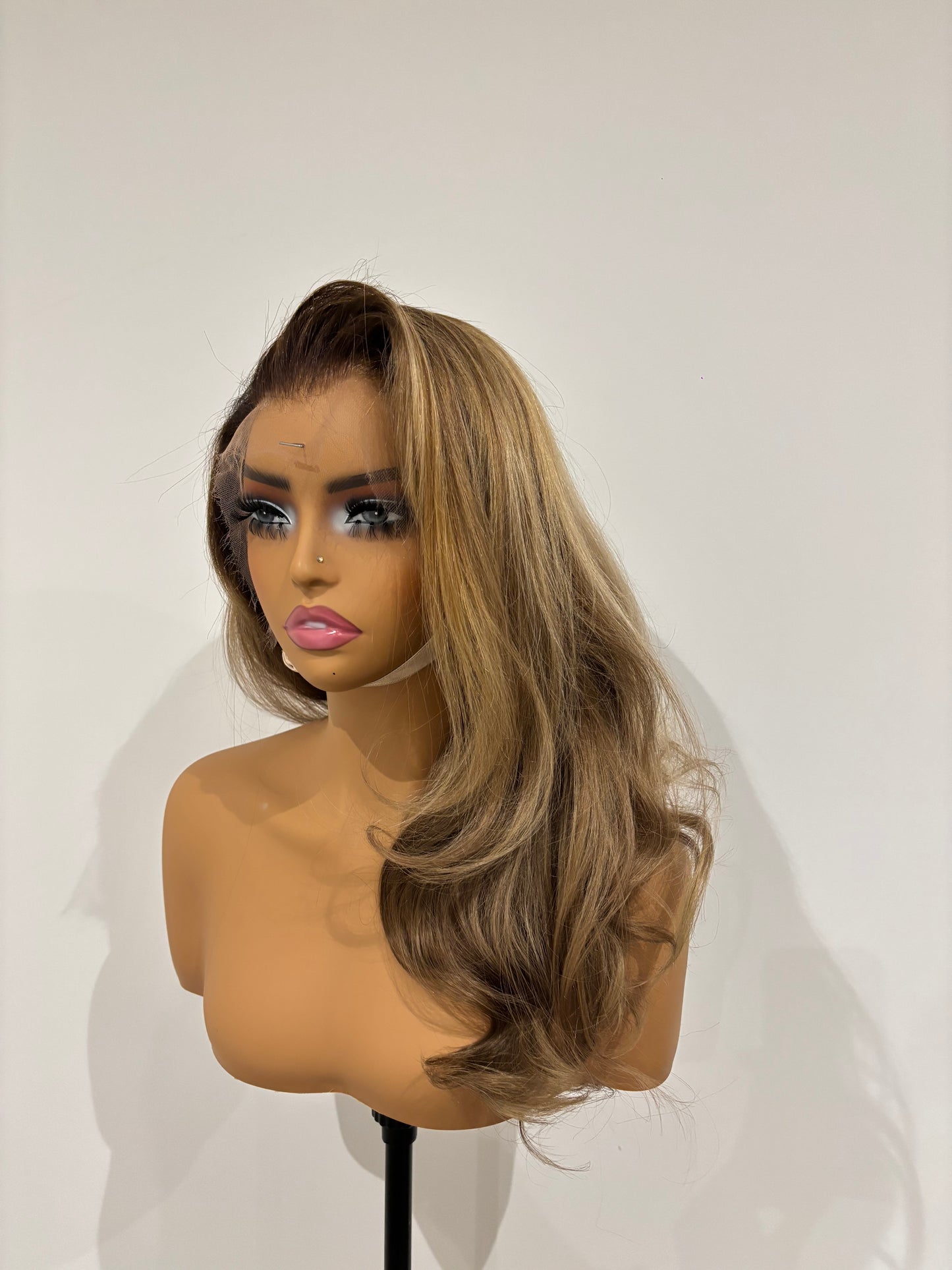 Bronde wig on a mannequin head against a white background